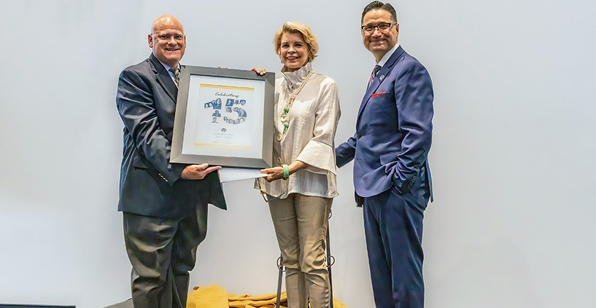 UC Merced Vice Chancellor and Chief External Relations Officer E. Edward Klotzbier, left, and Chancellor Juan Sánchez Muñoz, right, presented a special gift to Sherrie Spendlove during the program.