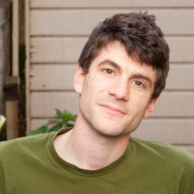 White man in green shirt looking at camera