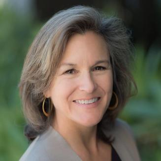 Headshot of Tracey Woodruff against a background of greenery