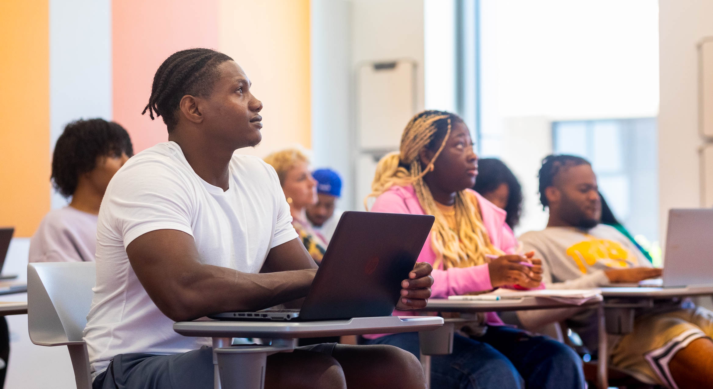Students sitting at desks listening attentively during a class