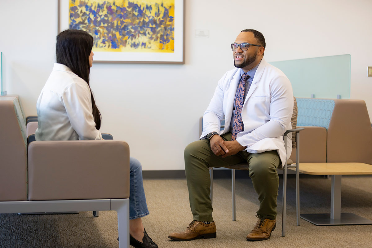 Chris Hall speaks with a patient in a waiting room