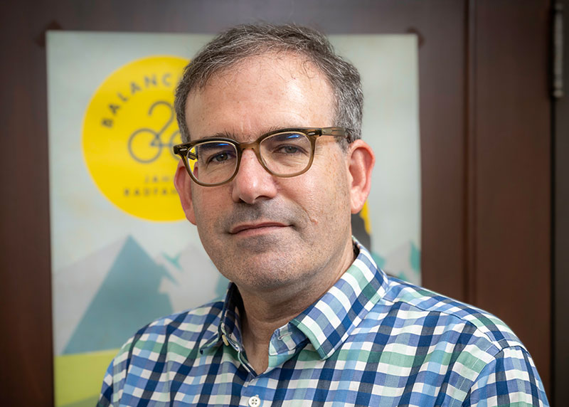 Dan Stamper-Kurn, wearing a plaid shirt in an academic office, smiles slightly at the camera.