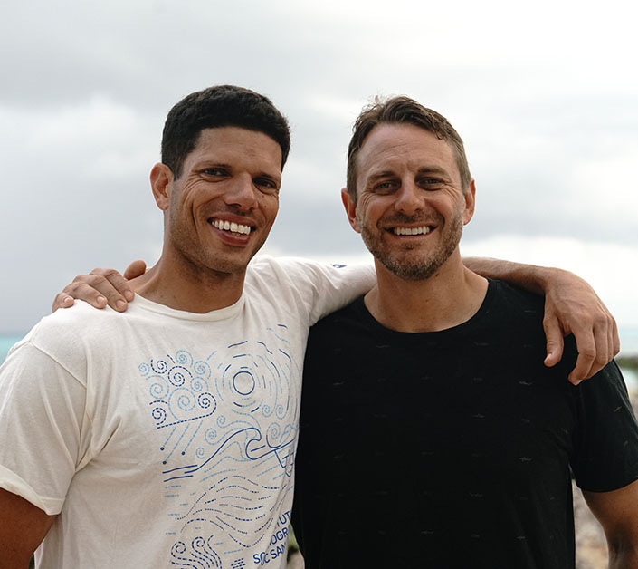 Two men with brown hair pose for the camera.