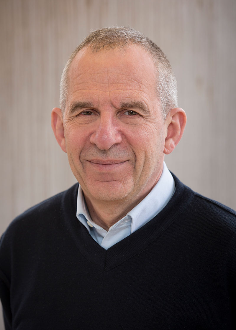Michel Devoret smiles at the camera wearing a black sweater