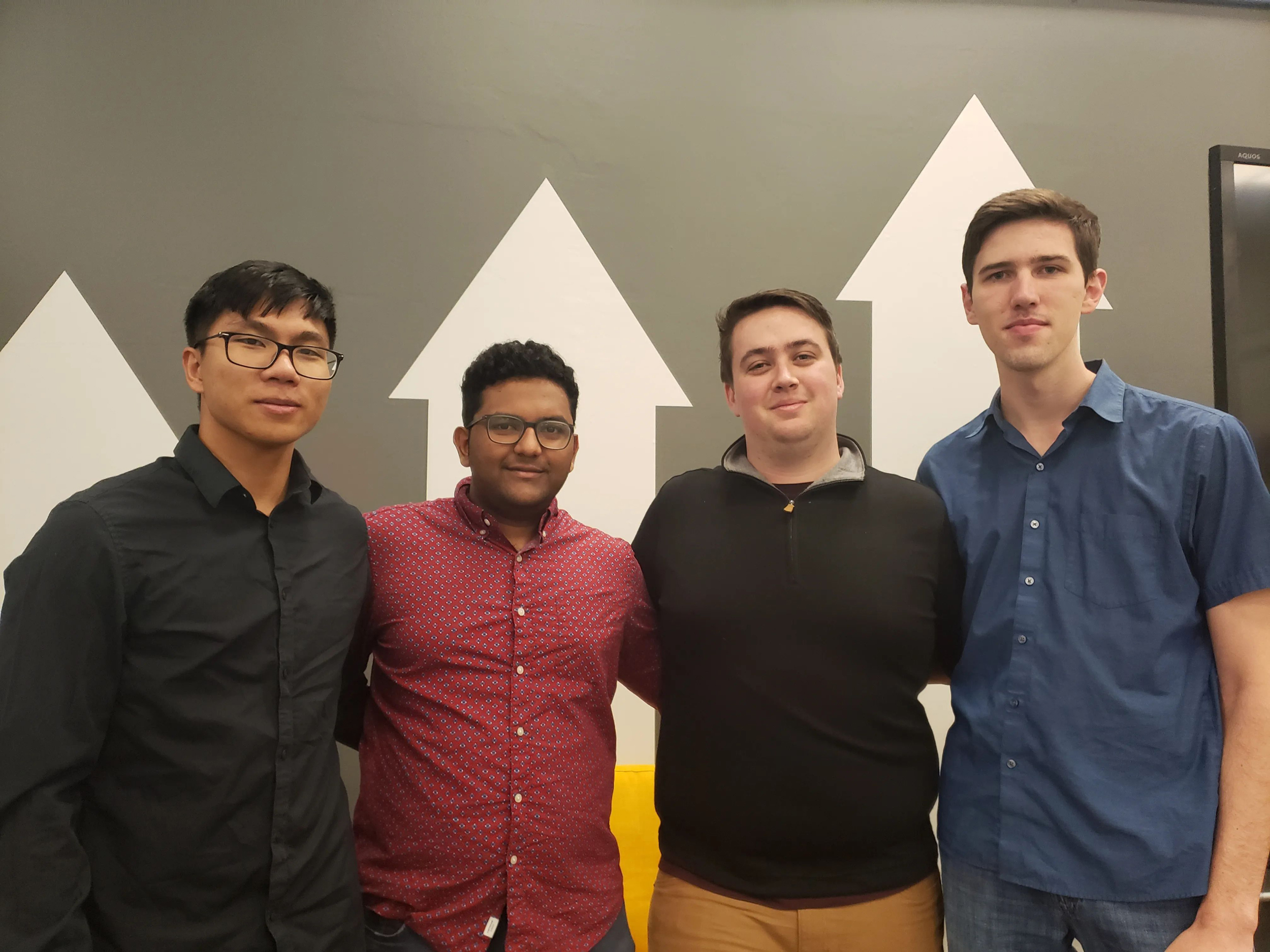 Four men stand together for a group photo