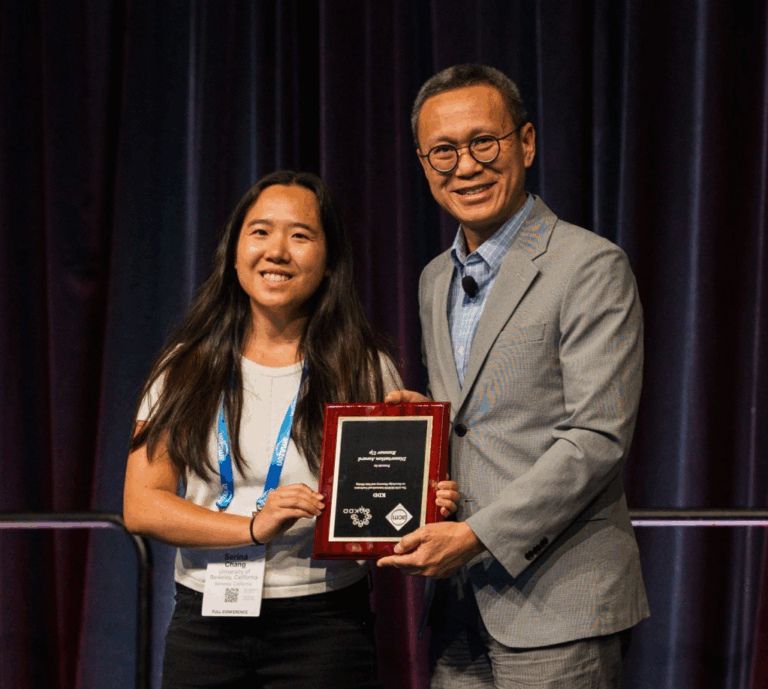 A woman holds a plaque with a man in a suit