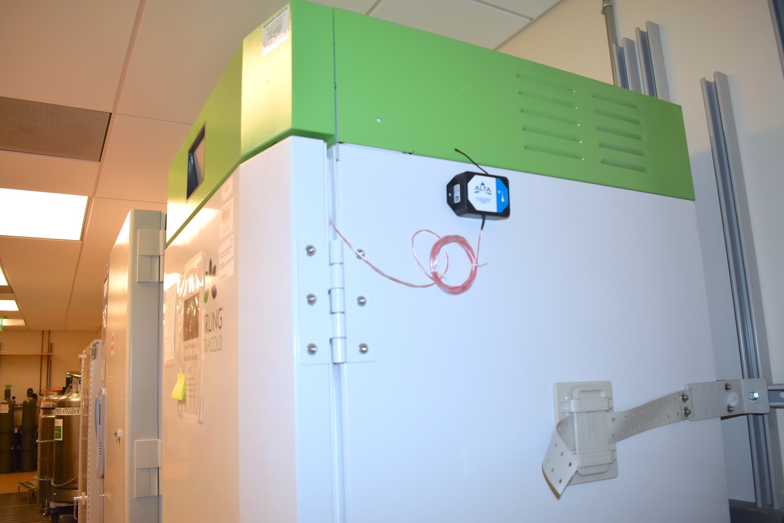 A bank of large white industrial freezers with green tops