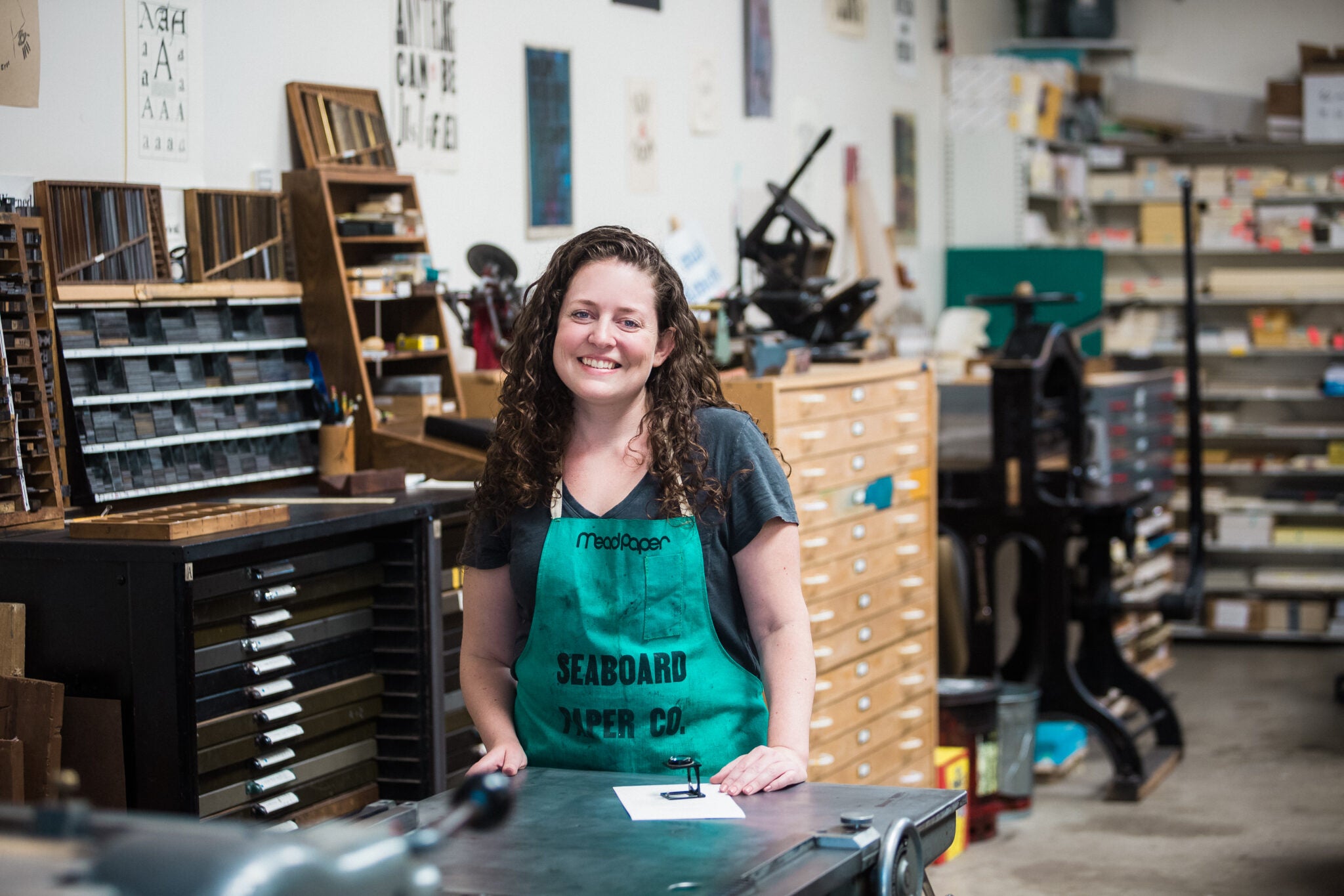 A woman in a green smock in a workshop