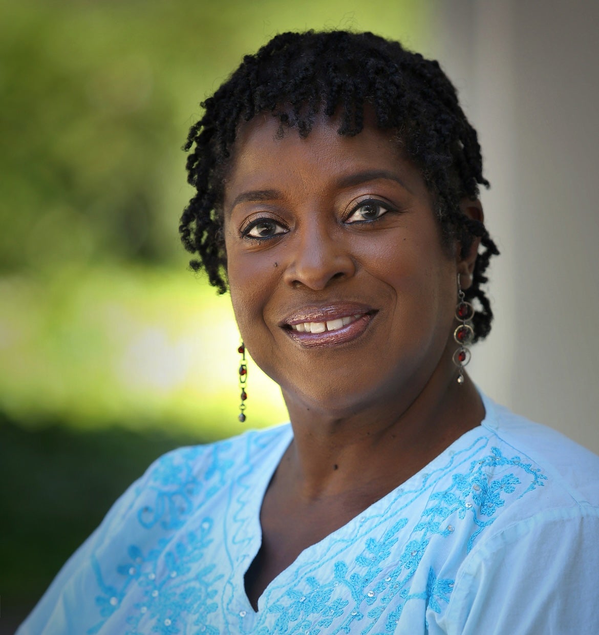 Woman with a bright blue top in a headshot