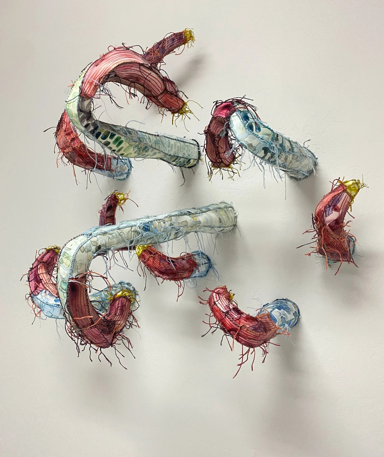 A series of worm-like protrusions through a wall