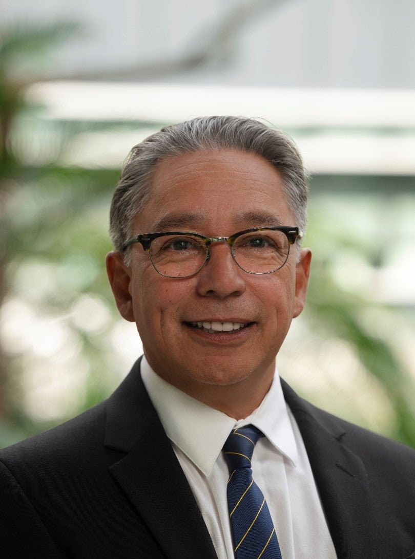 A man with glasses in a suit and tie