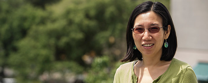 Engineering Professor Chen-Nee Chua sitting outdoors on a bench