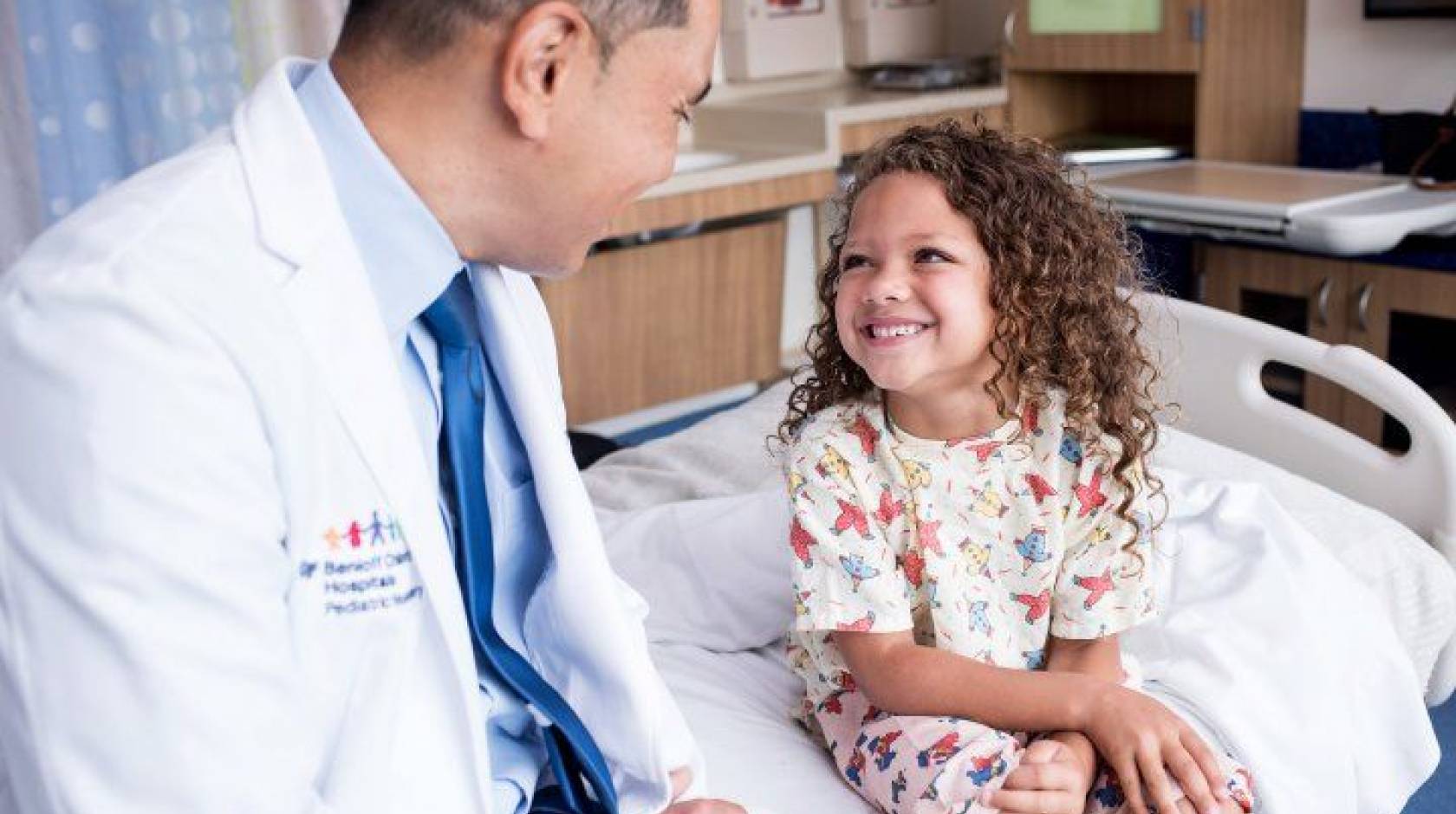 Kurtis Auguste, MD, a pediatric neurosurgeon, talks with a child in the Pediatric Brain Center at the UCSF Benioff Children’s Hospital.