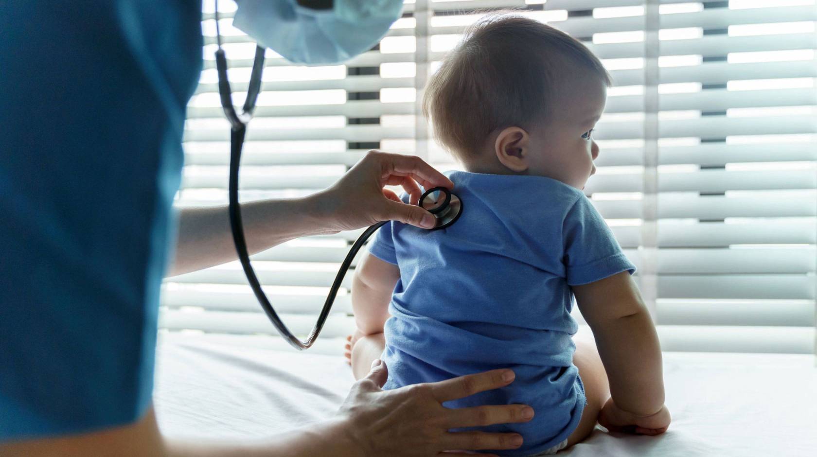 An infant getting checked by a pediatrician with a stethoscope