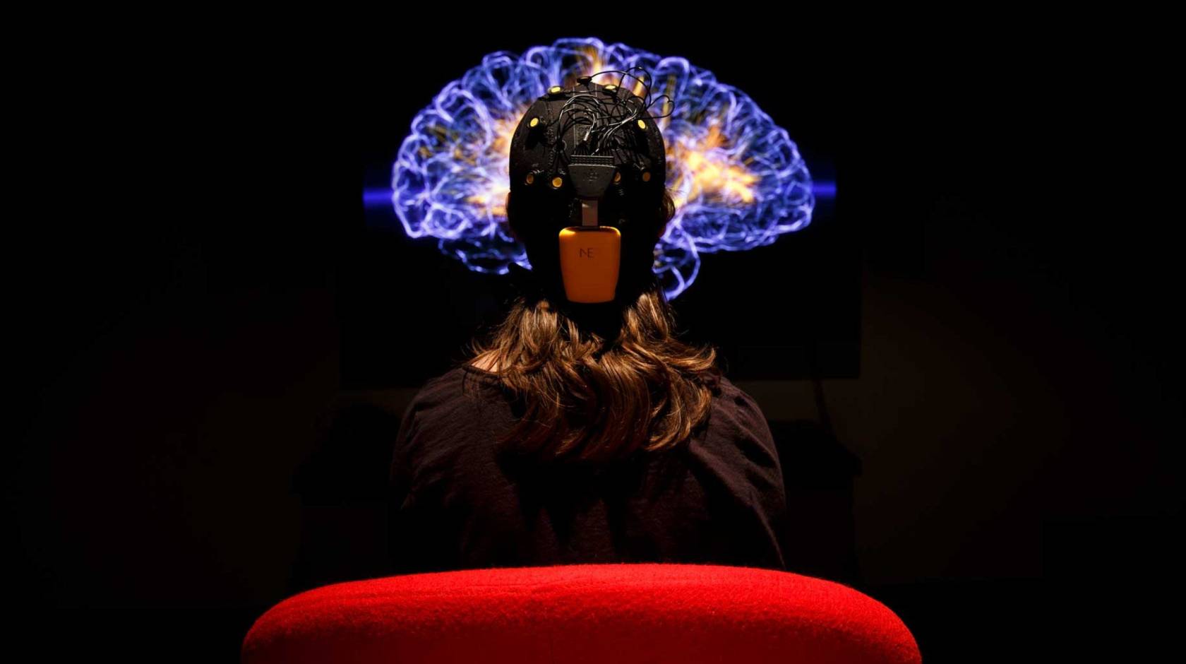 A person hooked up for an EKG looking at an image of the brain