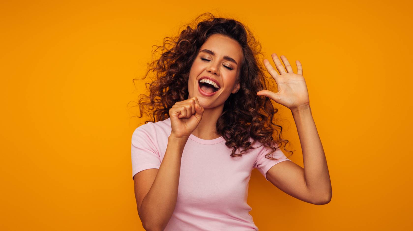 A woman singing into an air microphone