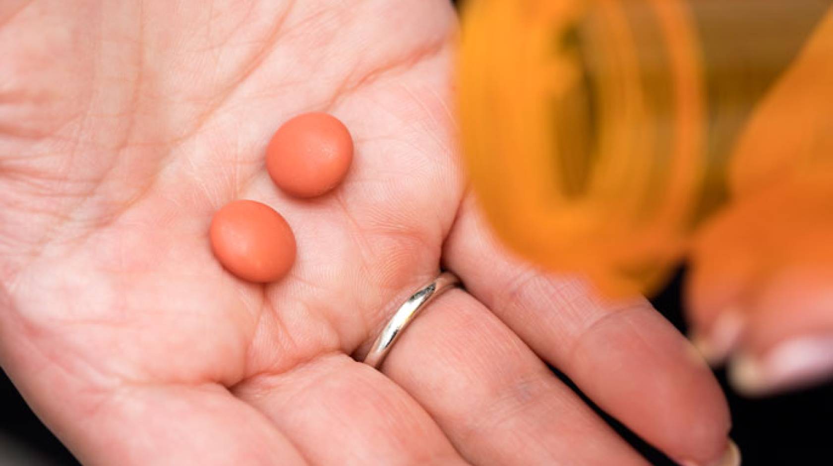 Ibuprofen pills in someone's hand