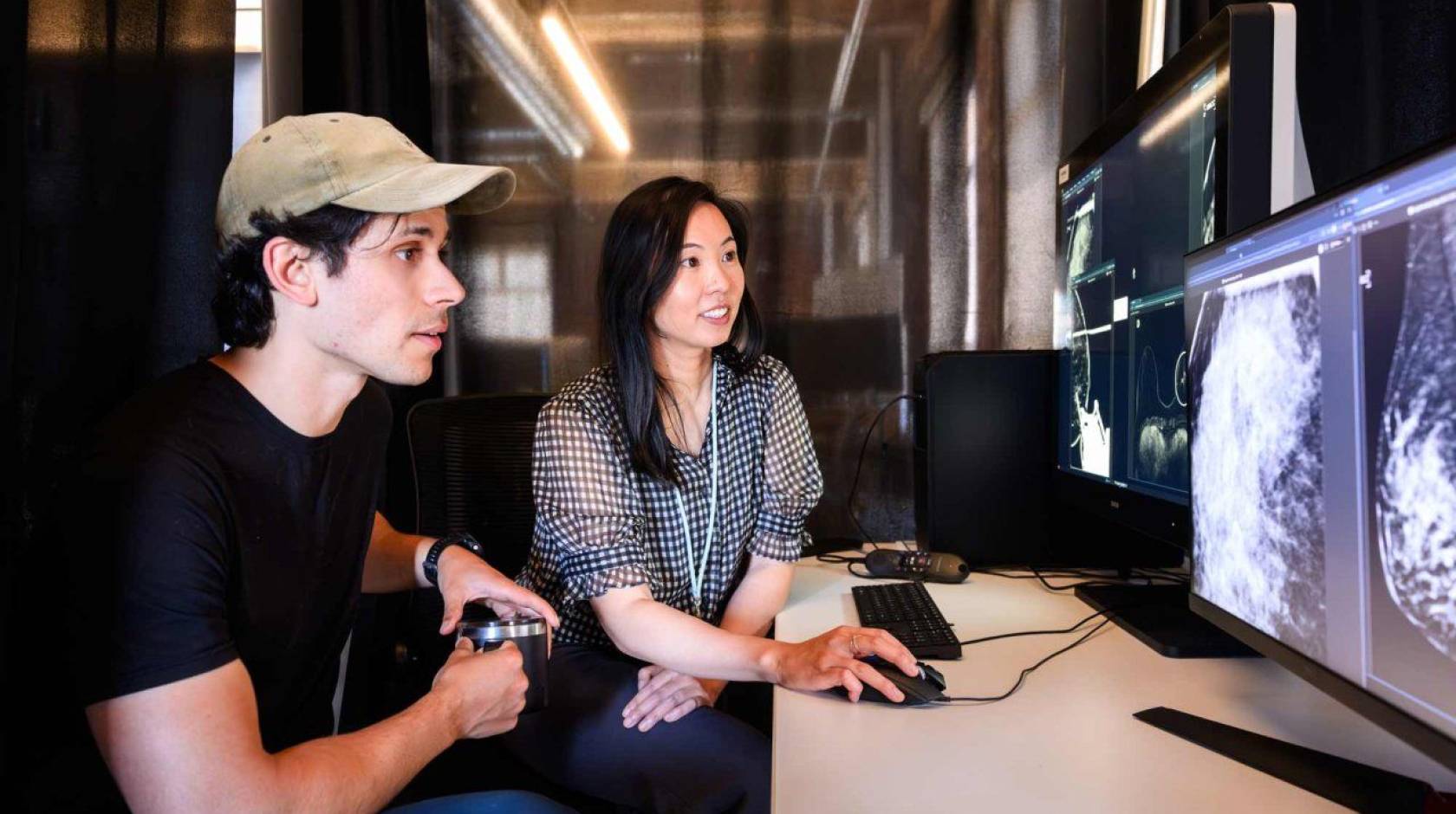 Researchers Maggie Chung and Adam Yala look at a mammogram scan on a computer screen