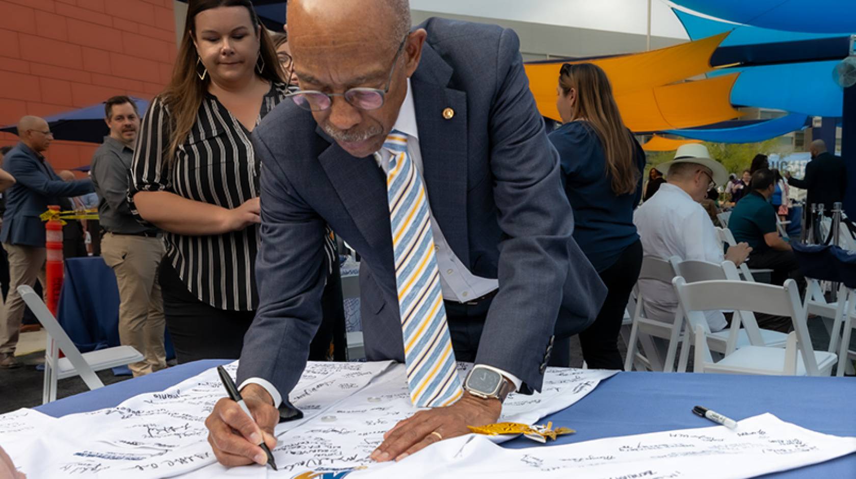 UC President Michael V. Drake M.D. signs a white coat