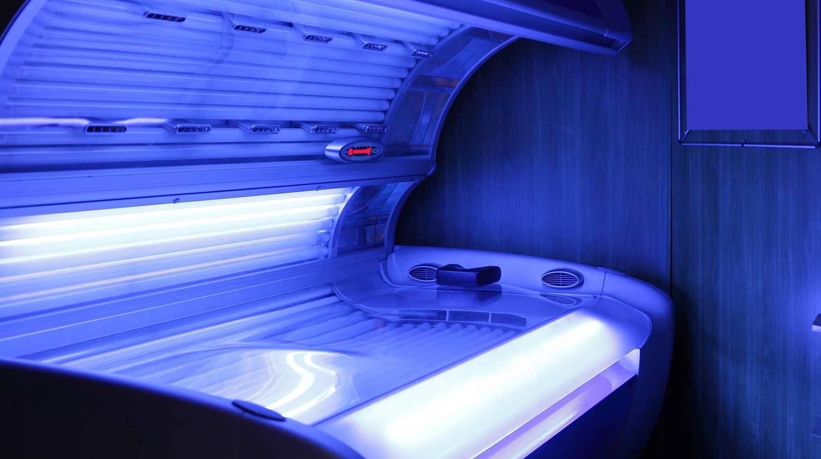A tanning bed emitting a soft blue glow.