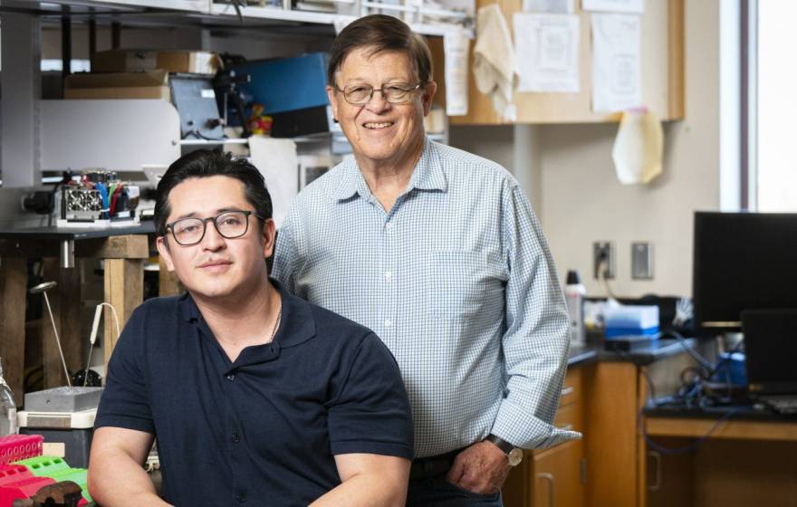 Two researchers wearing glasses posing in a lab