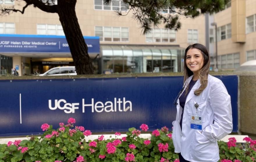 Vanessa Mora in her white coat in front of UCSF Fresno