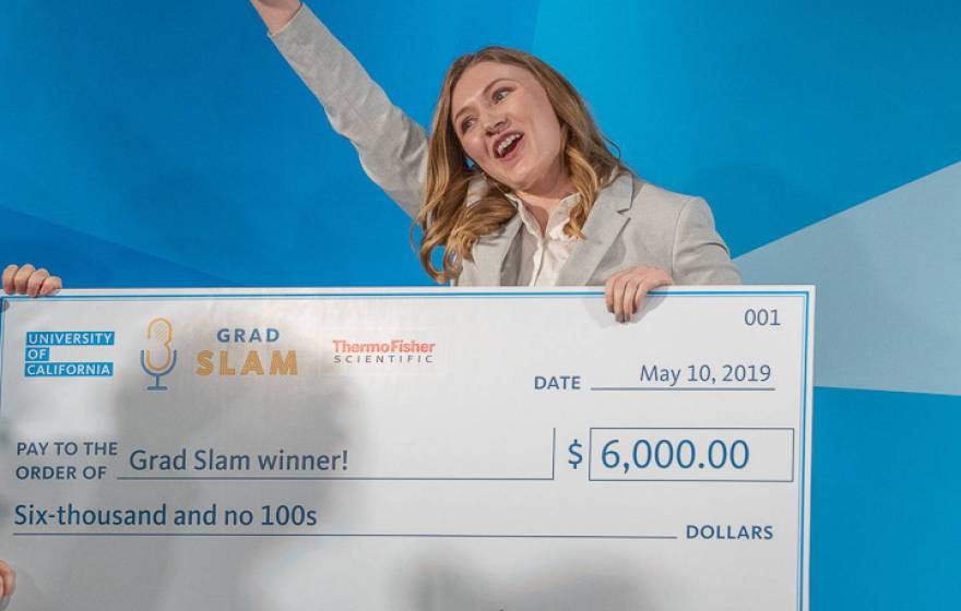 2019 Grad Slam winner Katie Murphy cheers with her trophy and giant check