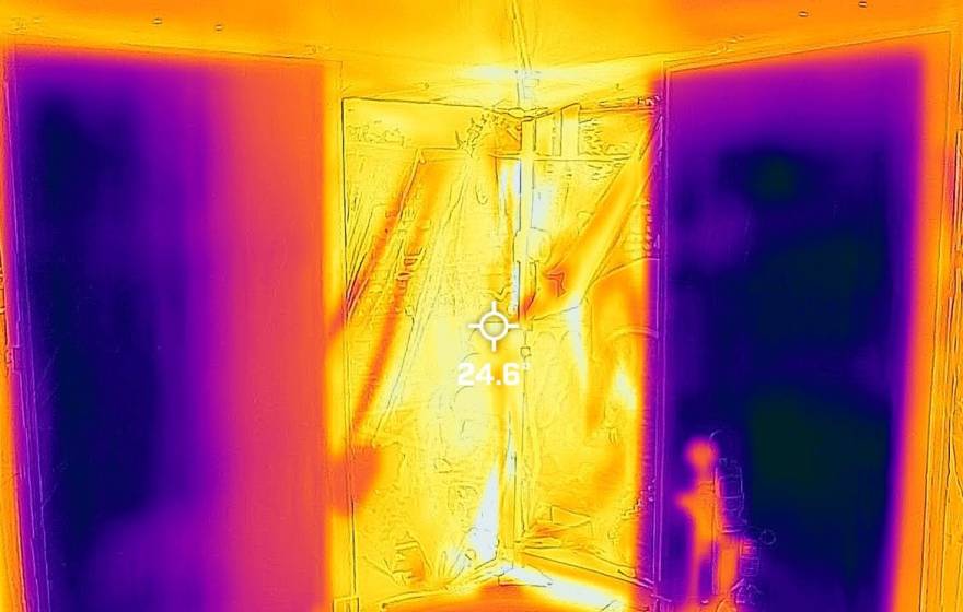 A thermal image with patches of bright yellow, orange, and purple