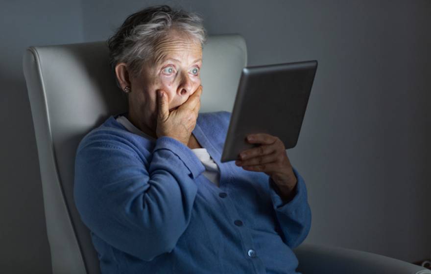 Shocked older woman watching TV on an iPad