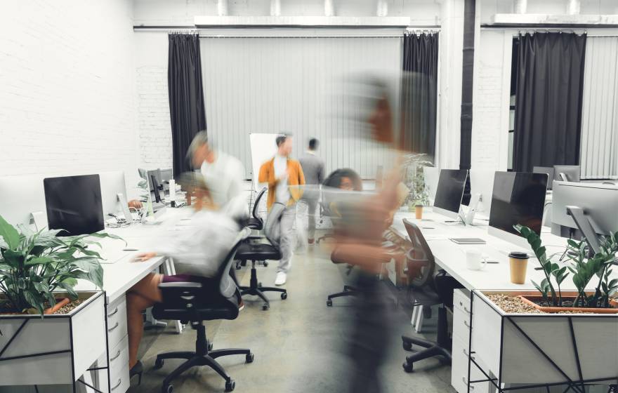 contemporary open space office interior with blurred coworkers in motion