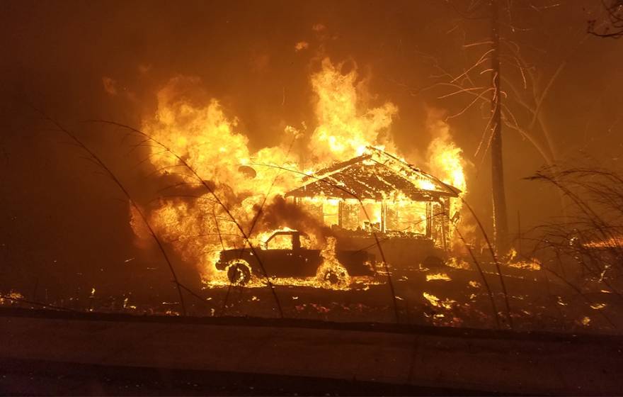 House and a truck on fire during the Camp Fire