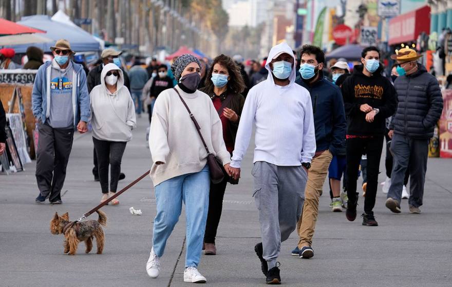 Group of people walking outside wearing masks