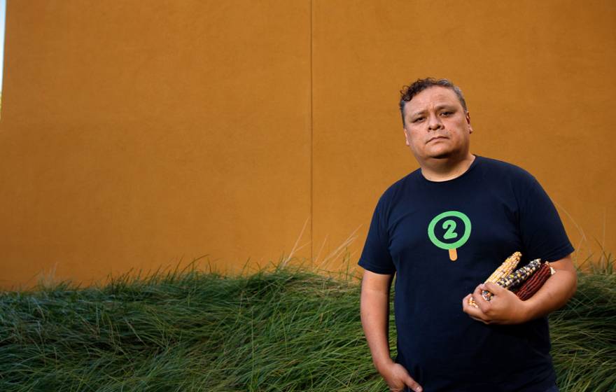 Edwin Solares outside at UC Davis holding the corn he studies