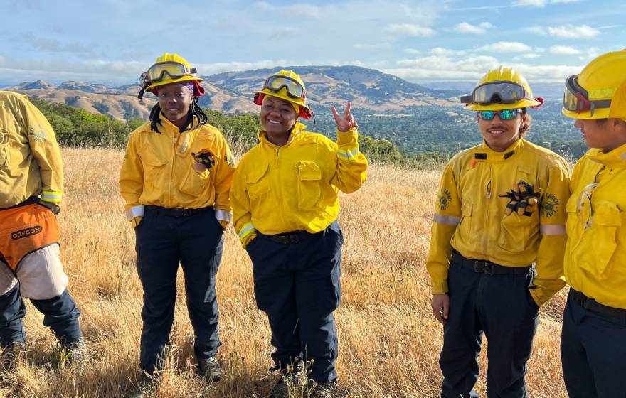 Young African American and Latino firefighters smile at camera