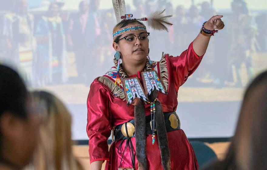 Young woman in tribal dress at the front of a classroom