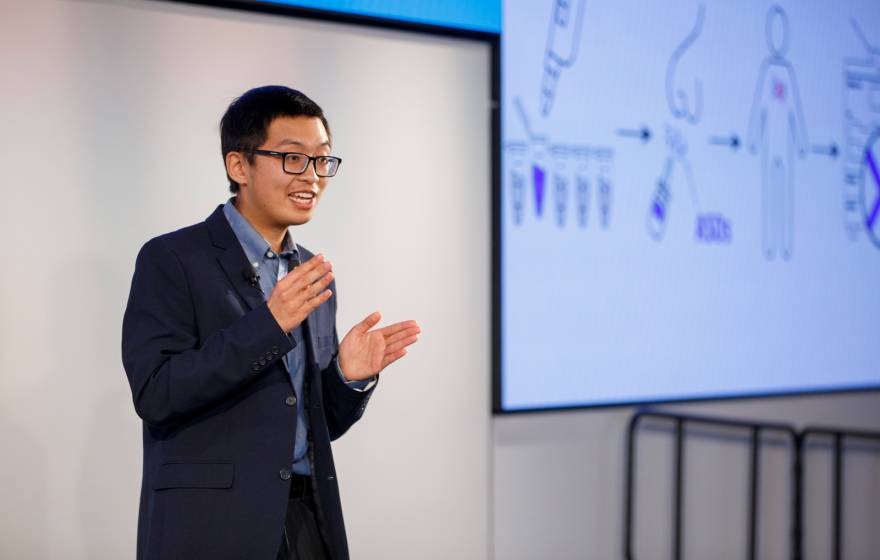 Justin Lee delivers his Grad Slam talk with a projected screen behind him