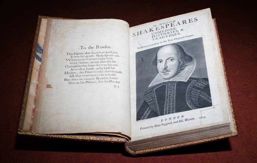 An old book open to a page showing a portrait of William Shakespeare