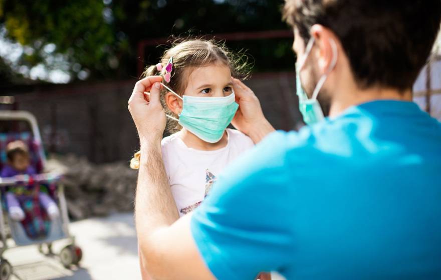 Man puts mask on child