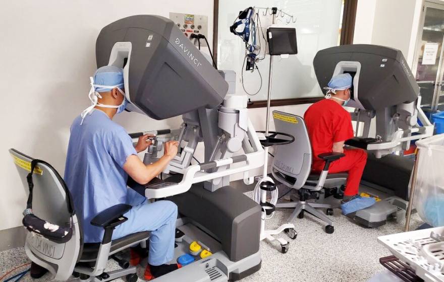 2 surgeons performing a cardiac surgery through machines