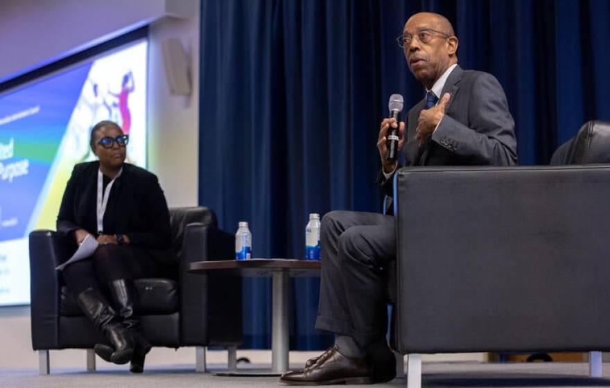President Drake on stage with a Black woman educator as part of a panel