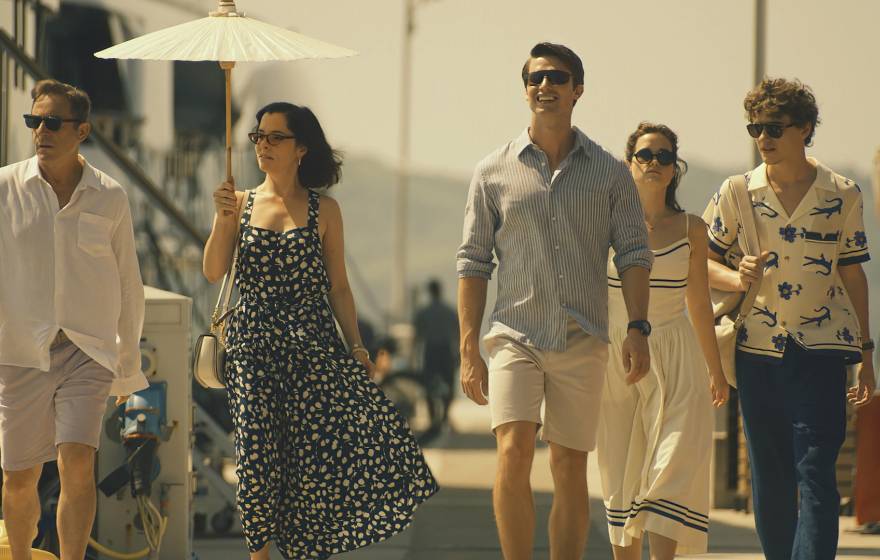 The five actors who play the Ratliff family walk down a gangplank on a pier together in a scene from The White Lotus