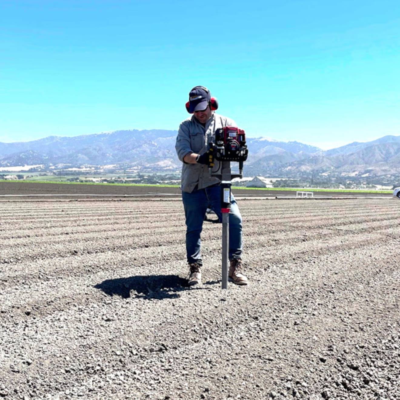 A man taking a soil sample in the middle of a dirt field