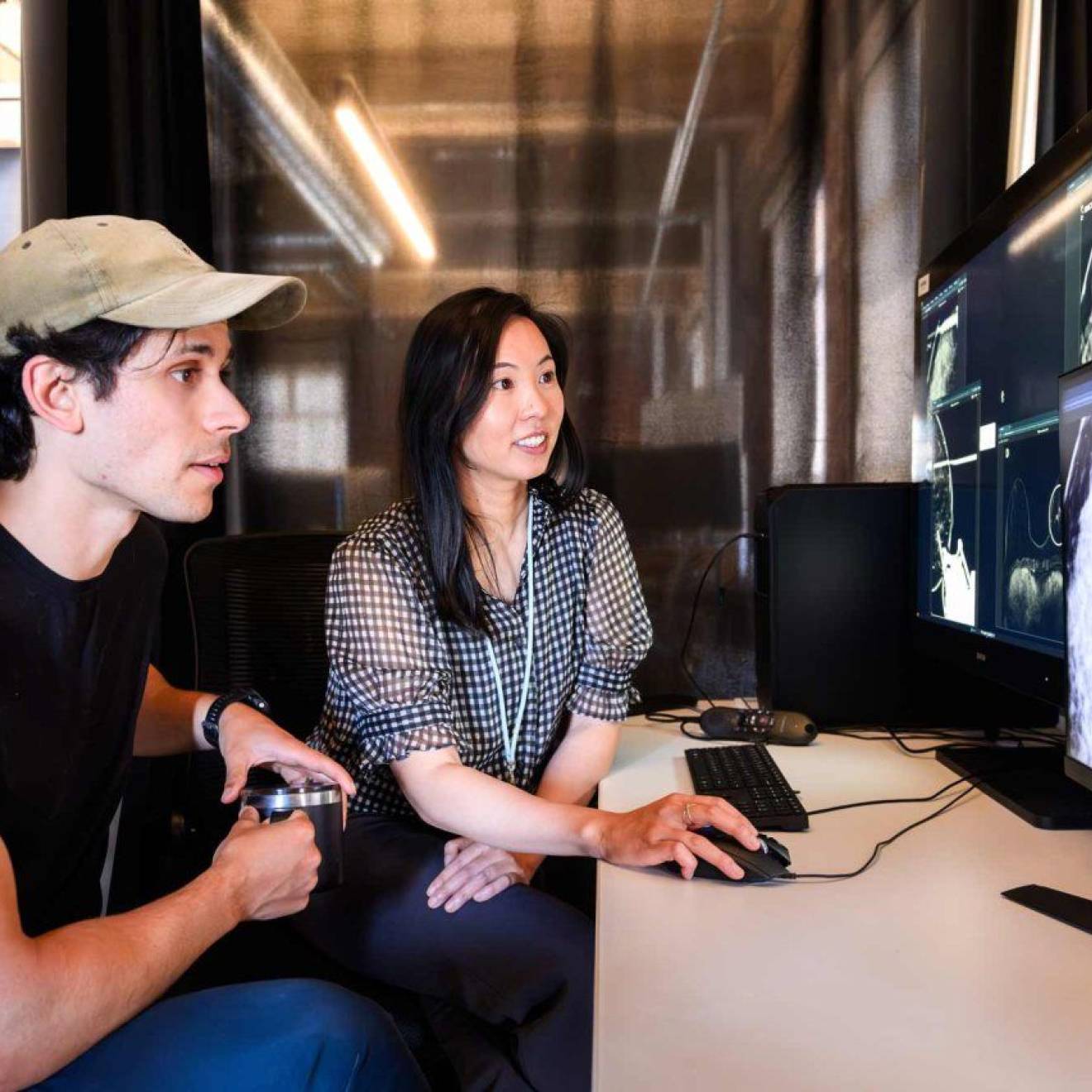 Researchers Maggie Chung and Adam Yala look at a mammogram scan on a computer screen