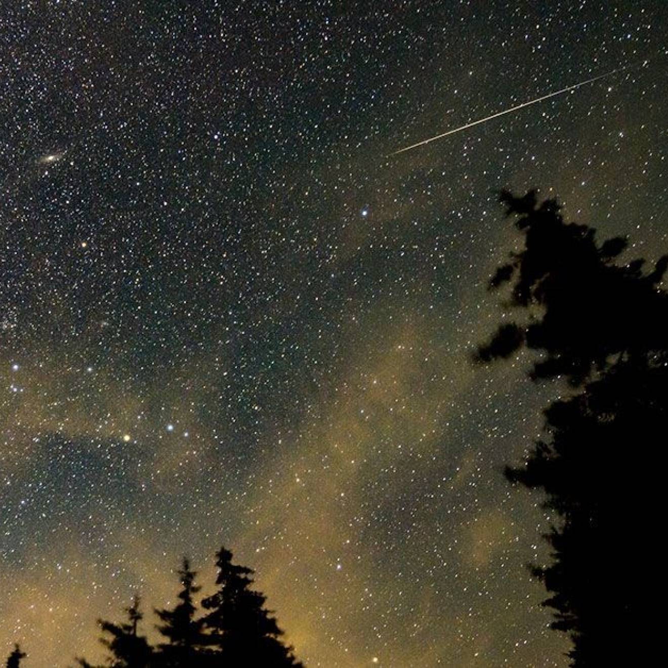 A view of a night sky with a meteor streaking across