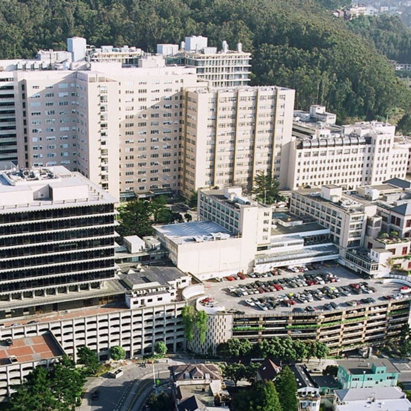 Aerial view of the UCSF Parnassus campus, white buildings at the base of a hill with trees