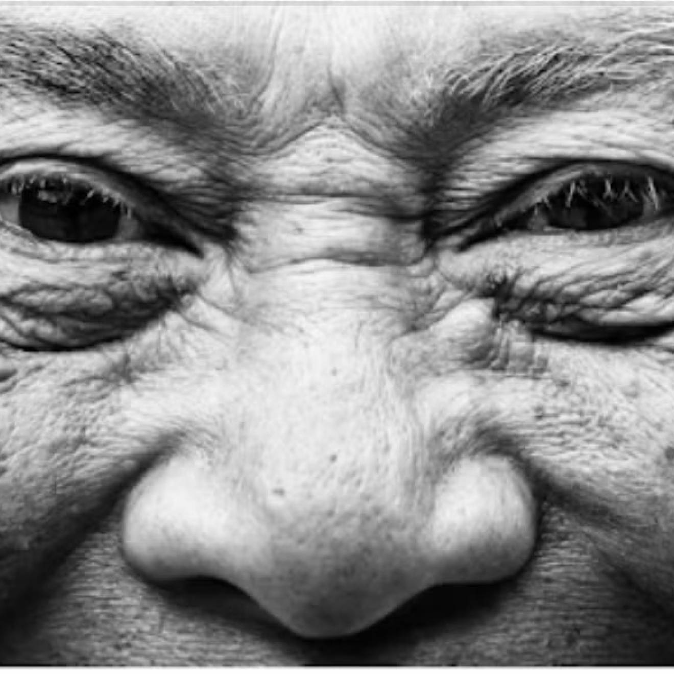 A close-up of an older person's smiling face and wrinkles