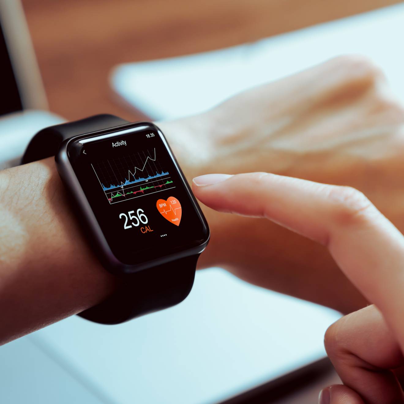 A person taps their smartwatch with the pointer finger of their other hand