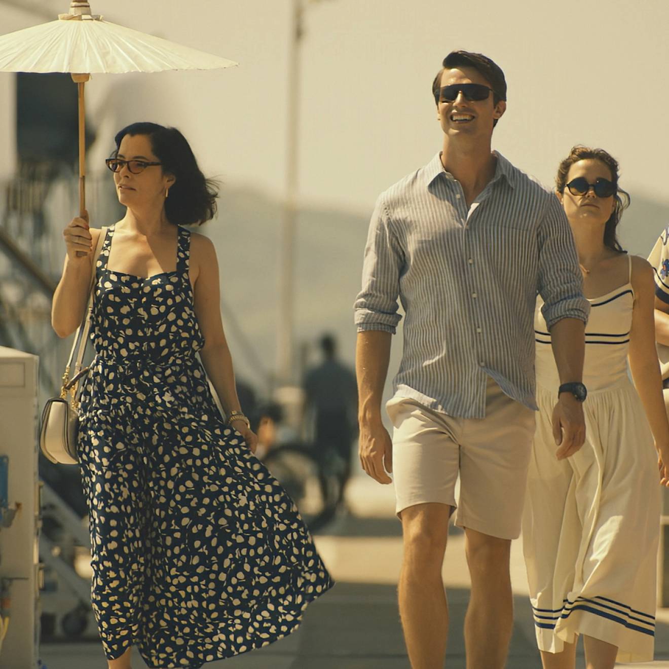 The five actors who play the Ratliff family walk down a gangplank on a pier together in a scene from The White Lotus